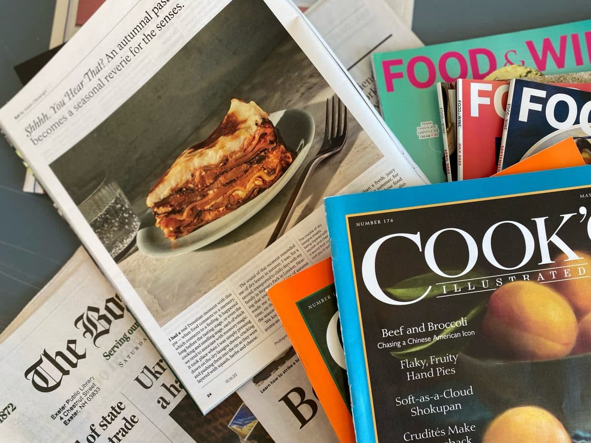 A spread of food writing journals and magazines on a table.