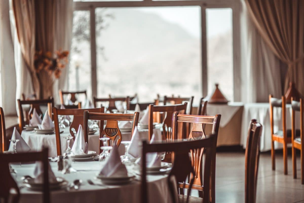 Elegant dining setup with wooden tables and white decor