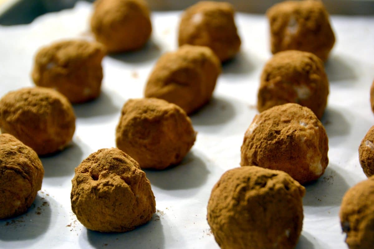 Round cocoa-dusted candies on a white surface.