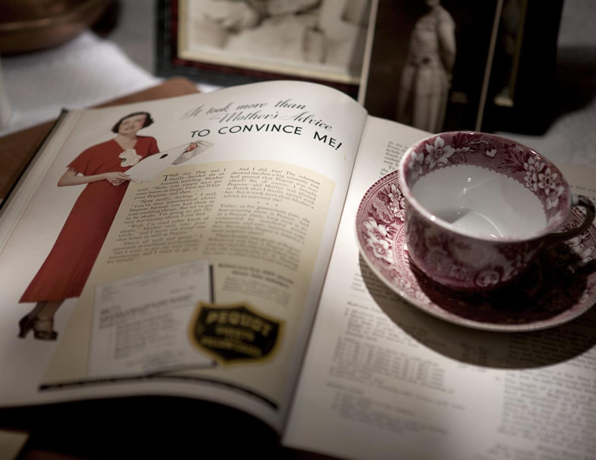 Vintage cookbook page displaying a woman in red attire and various text and advertisements.