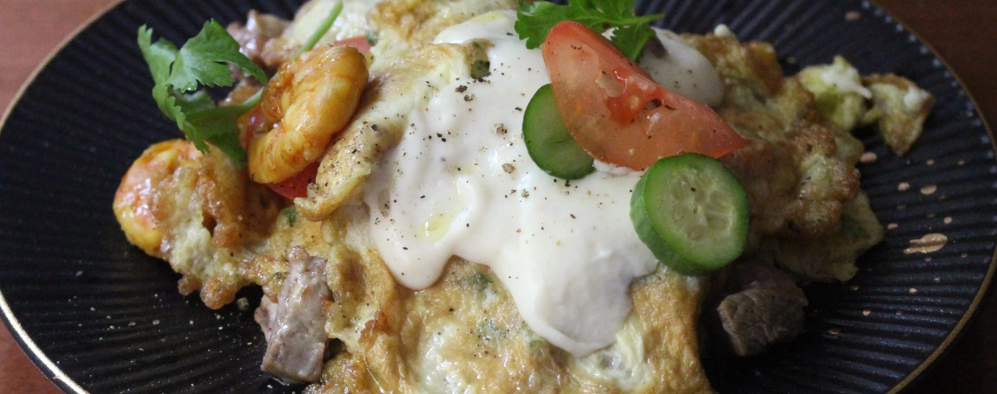Parsi poro layered with béchamel sauce, prawns, mutton, tomatoes and cucmber.