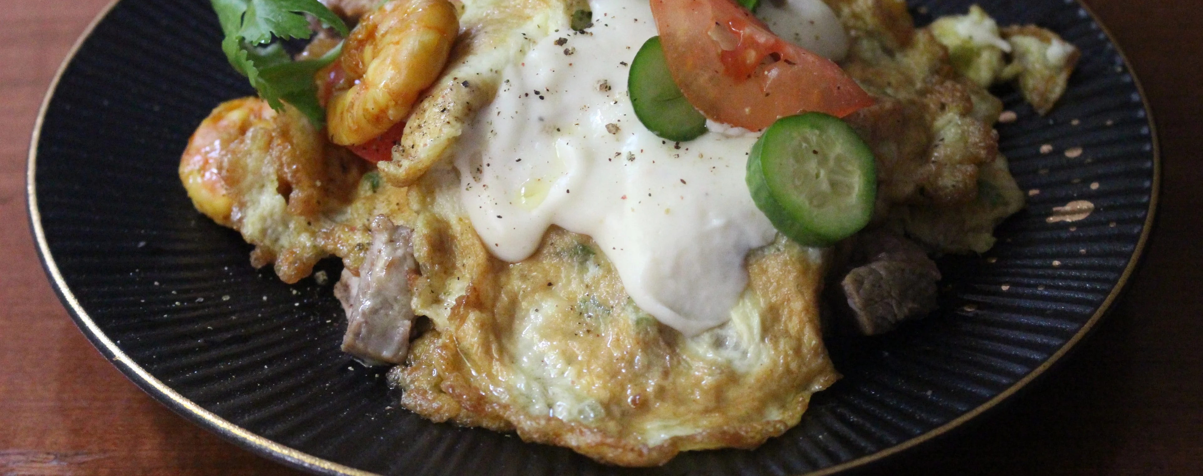 Parsi poro layered with béchamel sauce, prawns, mutton, tomatoes and cucmber.