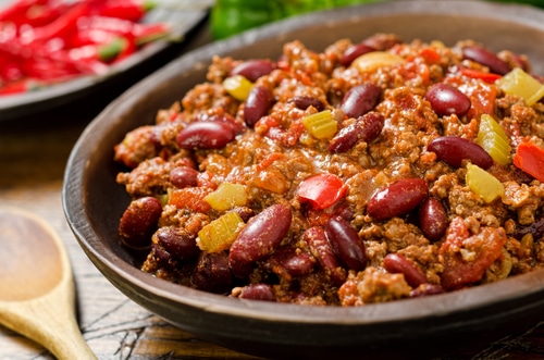 Hearty bowl of chili with ground meat, beans, and colorful bell peppers.