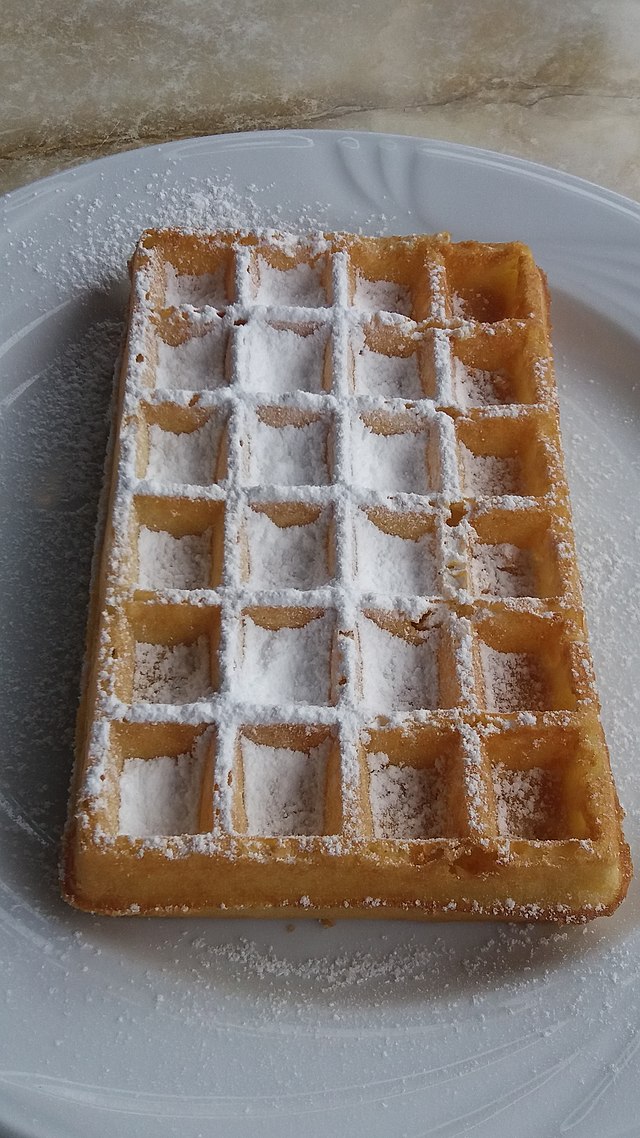 Close-up of a Belgian waffle with powdered sugar.