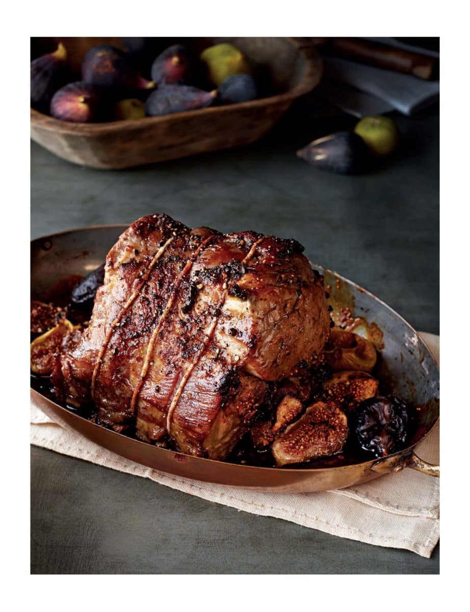 Roasted pork with figs and plums in a baking dish