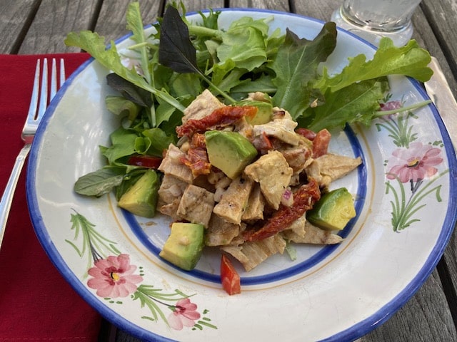 Chicken salad with fresh greens on a blue plate