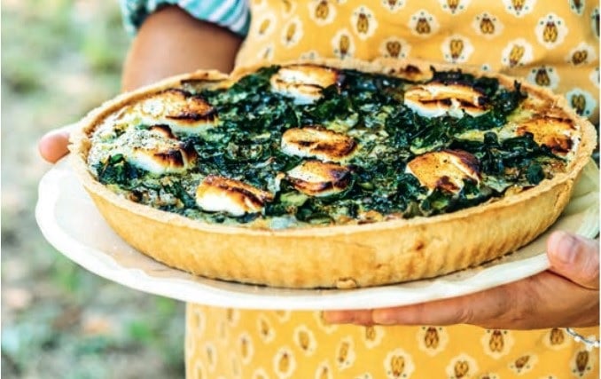 A freshly baked Tarte de Blettes with golden crust and green toppings.
