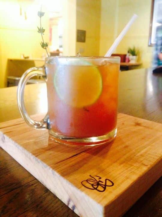 A cocktail in a glass with a lemon slice and straw named The New England Express.